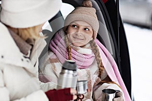 Focus on cute smiling girl in winterwear looking at her mother