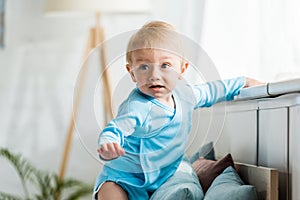 Focus of cute toddler kid in modern bedroom