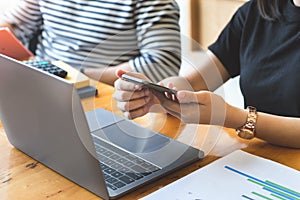 Focus on female employees using the phone while talking to male employees about workplace budgets.