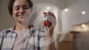 Focus on female hand holding bunch of keys from new home indoors