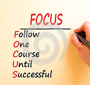 FOCUS follow one course until successful symbol. Concept words FOCUS follow one course until successful on white paper. Brown