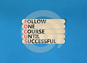 FOCUS follow one course until successful symbol. Concept words FOCUS follow one course until successful on wood stick. Blue