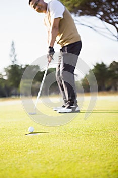 Focus on foreground of golf ball and a hole