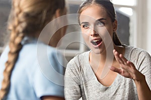 Young mother talking with daughter emotionally gesticulating using sign language