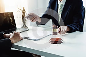 Focus at gavel, Attorney or Lawyer holding a pen is consulting with a client to explain the pattern of answering