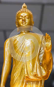 Focus on hand Yellow image of buddha standing