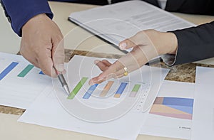 Focus at hands of business woman and supervisor are pointing graph chart during analyze the company`s sales plan at office