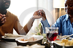 Focus on hands of young husband and wife during Thanksgiving pray