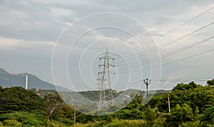 Focus on high voltage power transmission poles distributing power from hydro electric plant