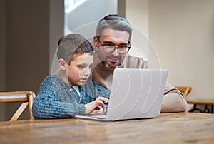 Focus and itll make sense. a father and son team using a laptop to complete school work.