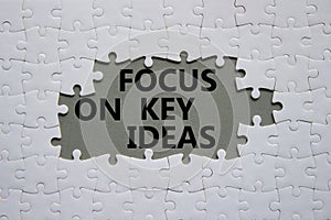 Focus on Key Ideas symbol. Concept word Focus on Key Ideas on white puzzle. Beautiful grey background. Business and Focus on Key