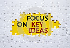 Focus on Key Ideas symbol. Concept word Focus on Key Ideas on white puzzle. Beautiful yellow background. Business and Focus on Key