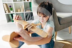 Focus of kid with dyslexia playing with wooden plane