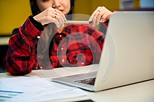 Focus on laptop and documents on desk during female call center operator working