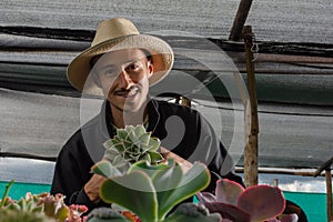 gardener showing camera an succulent plant in a pot photo