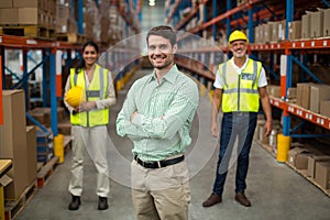 Focus on manager is posing with crossed arms in front of his workers