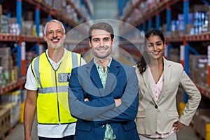 Focus of manager is smiling and posing in front of his colleagues