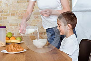 Focus of mother pouring milk in