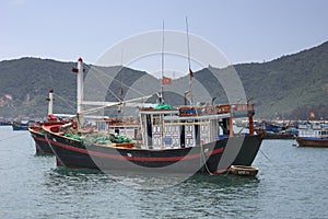 Focus on one fishing boat among many moored in front of village