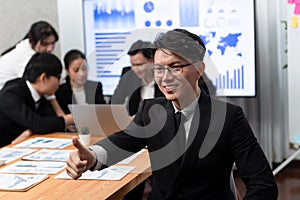 Focus portrait male manager in harmony office with businesspeople in background.