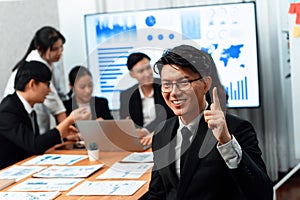 Focus portrait male manager in harmony office with businesspeople in background.