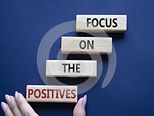 Focus on the Positives symbol. Concept words Focus on the Positives on wooden blocks. Beautiful deep blue background. Businessman