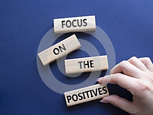 Focus on the Positives symbol. Concept words Focus on the Positives on wooden blocks. Beautiful deep blue background. Businessman photo