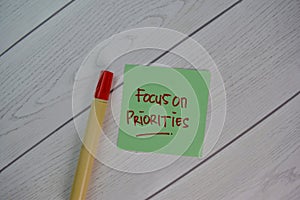 Focus on Priorities write on sticky notes isolated on Wooden Table