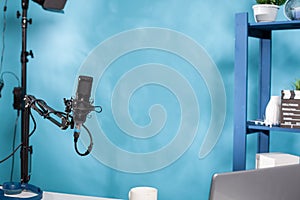 Focus on professional microphone swivel boom arm stand in empty podcast transmission studio