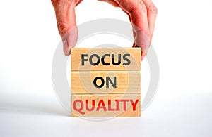 Focus on quality symbol. Concept words Focus on quality on blocks on beautiful white table white background. Businessman hand.