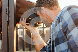 Focus of rancher leaning on horse