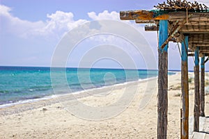 Focus on the reed pole for shade on the seashore. is a wonderful sunny day. Behind is a beautiful sea and blue sky. Copy Space