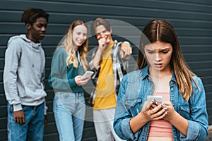 Focus of sad teenager holding smartphone