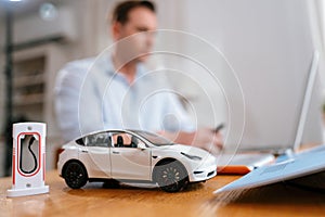 Focus scale EV car and charging station mockup model. Synchronos