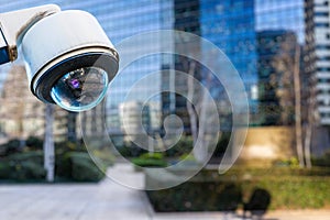 security CCTV camera or surveillance system with buildings on blurry background photo
