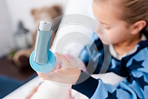 Focus of sick child holding inhaler