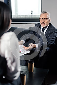 Focus of smiling businessman holding papers