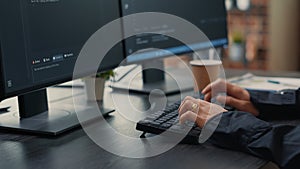 Focus on software developer hands typing source code on keyboard while looking at computer screen