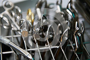 Focus on stainless steel professional dental extraction forceps being sterilized under UV inside an autoclave machine