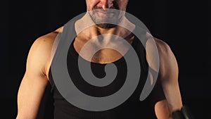 Focus on stomach. Dark contrast shot of young muscular fitness man stomach and arm