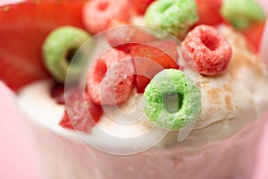 Focus of strawberry milkshake with ice cream and colorful candies