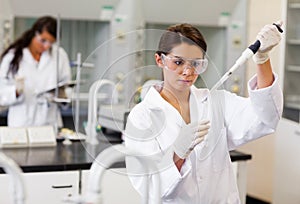 Focus student pouring liquid in a tube