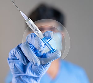 Focus on syringe, close up of doctor or nurse hands holding covid vaccination booster shot or 3rd dose syringe photo