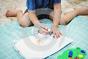 Focus on their hands on paper. Children use brushes to draw their hands on paper to build their imagination and enhance