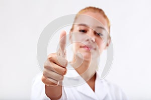 Focus on the thumb up, young woman blurred