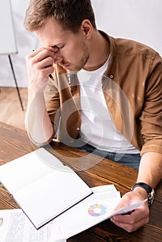 Focus of tired businessman holding papers