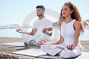 Focus to be free. Full length shot of a young couple practicing yoga at the beach.