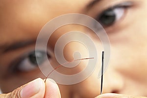 Concentrarse sobre el dar de coser hilo aguja 