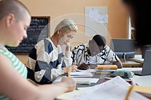 Focus on two young intercultural students carrying out examination test