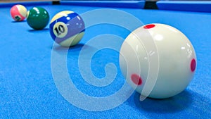 Focus on white ball of pool snooker on the blue table.